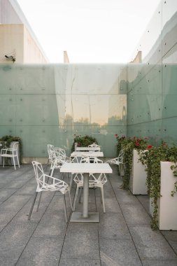 Saf ahşap sandalyeleri, masası, teras mobilyaları, sakin bahçe dekorasyonu, rahatlama yeri, modern köy dekoru olan rahat bir açık hava oturma alanı..