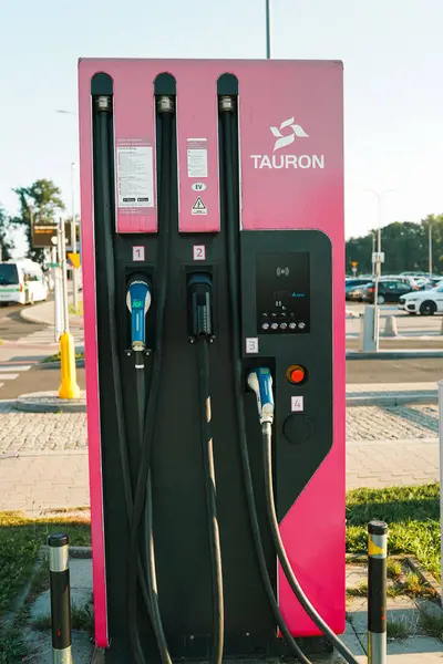 Krakow, Polonya - Aralık 2023: Tesla arabaları güneşli bir günde Tesla süper şarj istasyonunda şarj oluyorlar.
