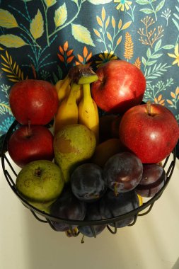 Tezgahta muz, elma ve kivi dolu bir meyve kasesi..