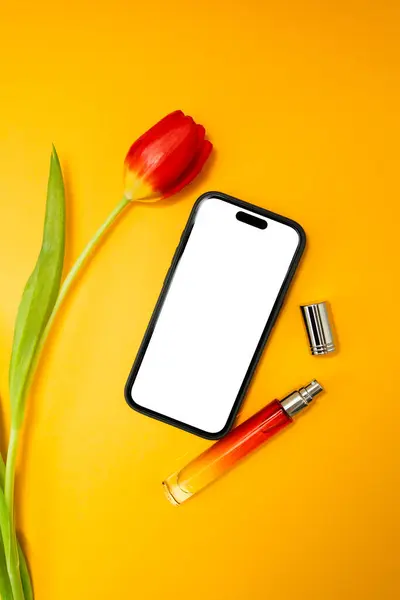 Sarı arkaplanda beyaz ekranlı, kırmızı laleli, reklam için düzenlenmiş, metin için kopyalama alanı olan telefon.