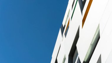 Mavi gökyüzü arkaplanı üzerine yeni bina mimarisi, modern gökyüzünün düşük açılı mimari dış görünümü,