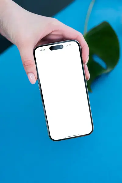 Kadın, uygulamalar ya da sunumlar için izole edilmiş beyaz ekranlı modern bir telefon tutuyor. Dijital içeriği veya mobil tasarımı göstermek için.