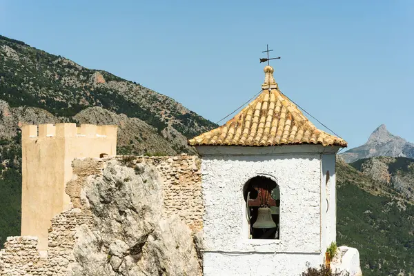 Eski taş çan kulesi dağın arka planında duruyor. Seyahat, mimari veya geçmişle ilgili içerik için uygun resim.