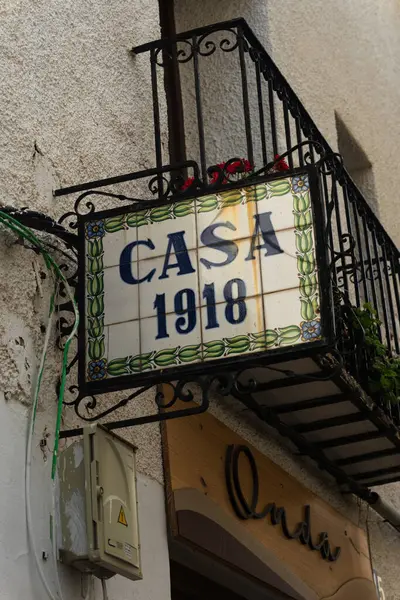 15 Mayıs 2025, İspanya, Guadalest: dekoratif seramik işaretli ev girişi. Kentsel ortamlarda tarihi mimari veya İspanyol ev dış görünüşlerini resmetmek için kullanışlı.