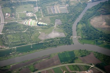Endüstriyel yapı ve nehri gösteren geniş bir hava manzarası var. Çevresel, altyapı veya arazi kullanımı için kullanışlı.