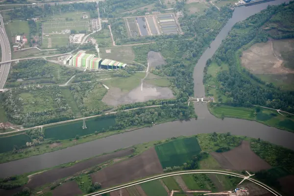 Endüstriyel yapı ve nehri gösteren geniş bir hava manzarası var. Çevresel, altyapı veya arazi kullanımı için kullanışlı.