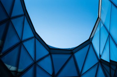 Açık mavi gökyüzünde cam ve metal cepheli çağdaş mimari binalar. Şehir tasarımı ya da modern inşaat kavramlarını resmetmek için. Metin için alanı kopyala