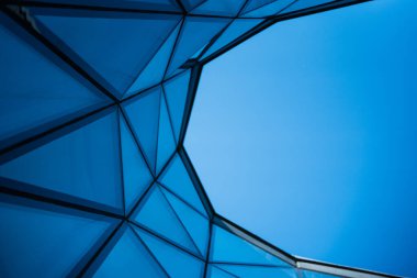 Açık mavi gökyüzünde cam ve metal cepheli çağdaş mimari binalar. Şehir tasarımı ya da modern inşaat kavramlarını resmetmek için. Metin için alanı kopyala