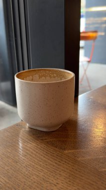 Ahşap yüzeyde basit seramik bardak. Modern ortamlarda kahve, çay veya içecek kavramlarının resmedilmesi için uygun görüntü.