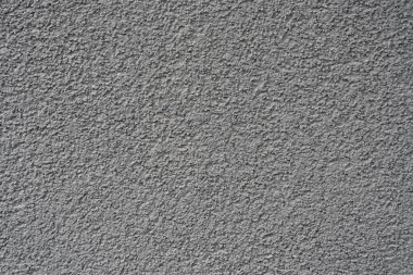 Ayrıntılı, kumlu bir dokusu olan pürüzlü gri beton yüzey. Arkaplan, tasarım projeleri veya mimari sunumlar için uygundur