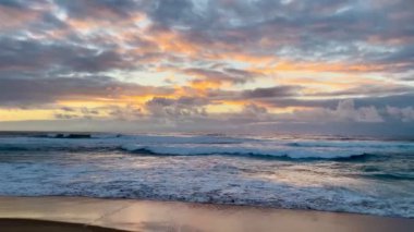 Ocean Waves Crashing on sandy Shoreline, sunset in Portugal