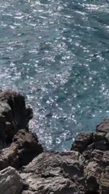 Deniz arka planı, kayalık kıyı şeridi güneş ışıkları. Yüksek kaliteli FullHD görüntüler