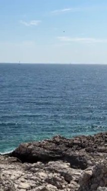 Deniz arka planı, kayalık kıyı şeridi güneş ışıkları. Yüksek kaliteli FullHD görüntüler