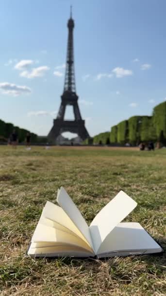 Wind Flipping Notebook Páginas Sobre Campo Hierba Francia Torre Eiffel — Vídeo de stock