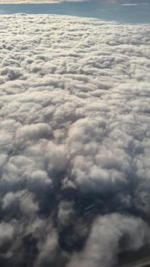 Gündüz uçuşu sırasında Uçak Koltuğu 'ndan güzel beyaz bulutlar. Yüksek kalite 4k görüntü
