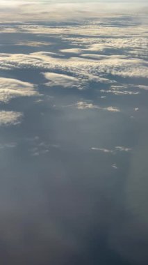 Gündüz uçuşu sırasında Uçak Koltuğu 'ndan güzel beyaz bulutlar. Yüksek kalite 4k görüntü