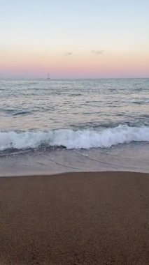 Mavi Saatteki Nazik Pembe Deniz Dalgası, Yumuşak Işık ve Sakin Suyla Romantik Sahil Arkaplanı. Yüksek kalite 4k görüntü