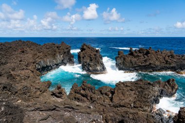 Waianapanapa Eyalet Parkı 'nın tropikal bir manzarası olan Maui' de dağların üzerinde fırtına bulutları oluşuyor.
