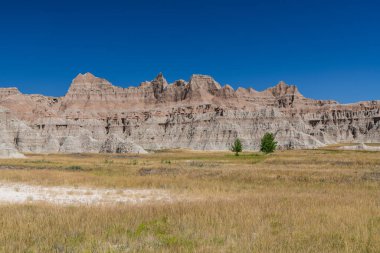 Güney Dakota 'daki Badlands Ulusal Parkı' nda çimenli bir çayırın üzerindeki renkli tepeler