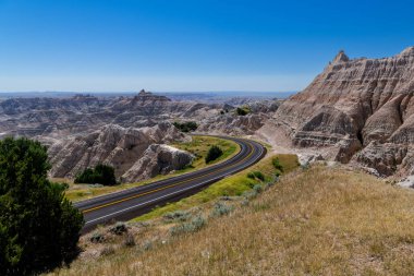 Güney Dakota 'daki Badlands Ulusal Parkı' nın renkli manzaraları boyunca kıvrılan otoyol.