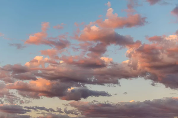 Sunset cloudscape of pink and purple clouds and blue sky, background image