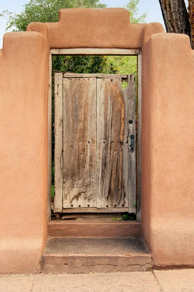 stock image Weathered wood gate to garden in adobe wall in Santa Fe, New Mexico