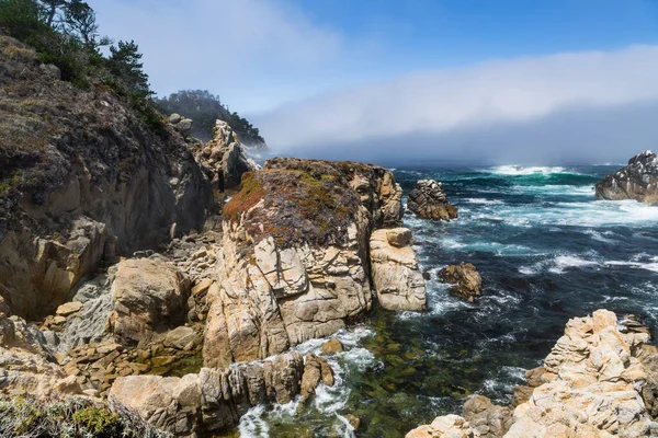 カリフォルニア州カーメルのポイント ロボス州立保護区の海と霧の上の花崗岩の崖と岩 — ストック写真