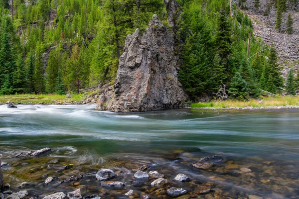 Yellowstone Ulusal Parkı 'ndaki kayaların üzerinden geçen uzun bir nehir sızıntısı.