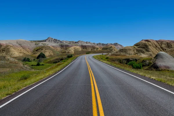 Autostrada Przez Krajobraz Trawiastych Łąk Kolorowych Szczytów Parku Narodowym Badlands — Zdjęcie stockowe