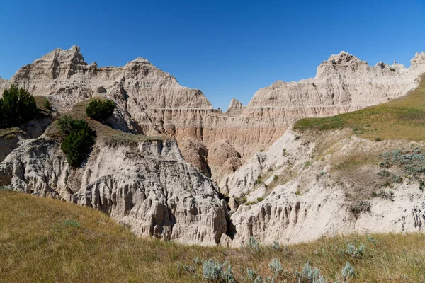 Güney Dakota 'daki Badlands Ulusal Parkı' nda çimenli bir çayırın üzerindeki renkli tepeler