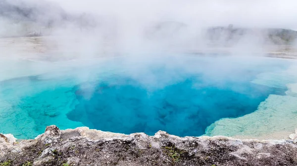 Yellowstone Ulusal Parkı 'ndaki Excelsior Gayzer' de berrak su ve buhar gölgeleri.