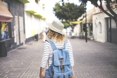 Genç, güzel, kıvırcık bir kadının portresi. Sokakta yürürken dükkanlara bakıyor. Yeni yerler keşfediyor ve geziyor. 