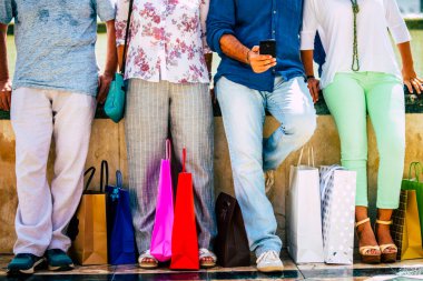 group of four people at mall buying clothes and gift for Christmas together - shopping center with discount and money off  clipart