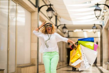 Elinde çantasıyla yürüyen ve koşan bir kadının alışverişe daha çok gitmesi - para harcamak ve moda olmak. 