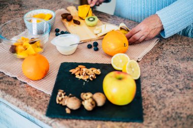 Üstten görünüm kadının bıçakla kesme taze portakal eller. Kadın yapma taze meyve salatası. Vejetaryen kavramı 