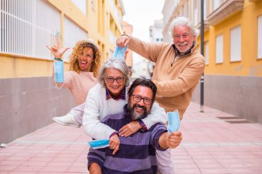 Bir grup mutlu ve neşeli insan, yeni normallikte karantina ve salgın sonrası orta maske takmadan eğleniyor ve eğleniyor. 