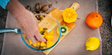 Top view of woman hands cutting fresh oranges with knife. Female making fresh fruit salad. Vegetarian concept clipart