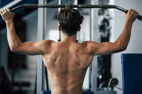 Spor Salonunda Tişörtsüz Bir Genç Sırtı Için Egzersiz Yapıyor Ağırlıklı — Stok fotoğraf
