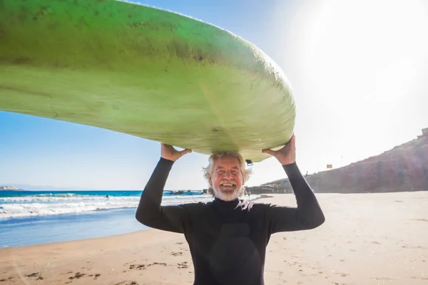 머리에 거침없는 상급생 미소짓고 나이가 남자가 잠수복을 재미있는 서핑을 활동하고 — 스톡 사진