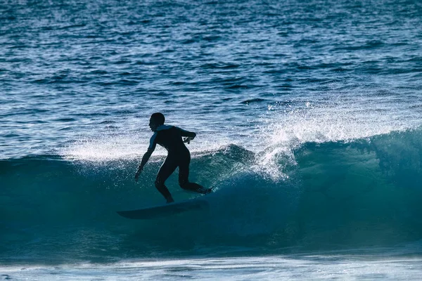 1人の男は夏や冬にウェットスーツを使って休暇中に訓練やサーフィンをしています カナリア島の美しく大きな波 — ストック写真