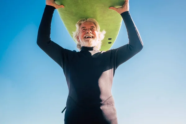 머리에 거침없는 상급생 미소짓고 나이가 남자가 잠수복을 재미있는 서핑을 활동하고 — 스톡 사진