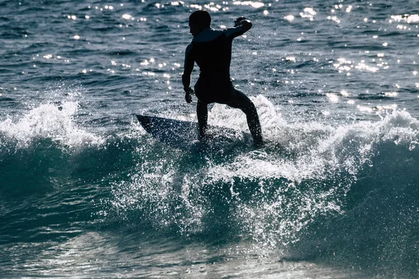 十代の若者たちはアメリカのテネリフェビーチで波に乗ってサーフィン 白と黒のウェットスーツと美しいと小さな波 — ストック写真