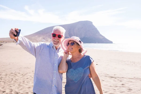 Dos Personas Maduras Tomando Selfie Playa Sonriendo Divirtiéndose Disfrutando Jubilados —  Fotos de Stock