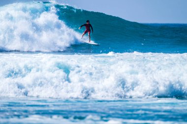 Bir adam yaz ya da kış tatillerinde dalgıç kıyafetiyle eğitim ve sörf yapıyor. Kanarya adasında güzel ve büyük bir dalga. 