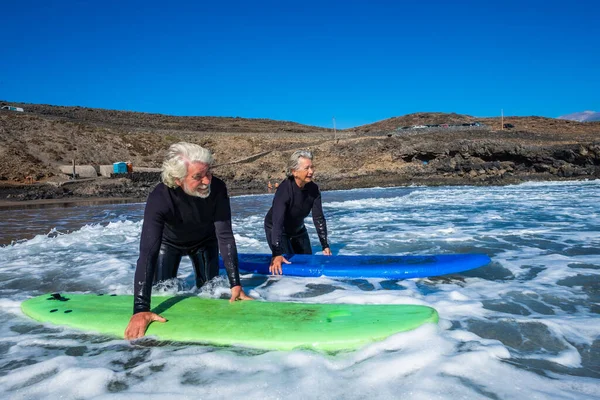 Coppia Anziani Spiaggia Con Mute Nere Che Tengono Tavolo Surf — Foto Stock