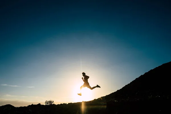 stock image teenager running alone at the mountain with sunset - man jogging - positive vibes 