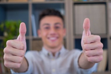 Erkek eline odaklan ve başparmak işareti yap. Gülümseyen çekici beyaz erkek çalışanı iyi hizmet öneriyor, uluslararası şirkette başarılı bir kariyerden memnun.. 