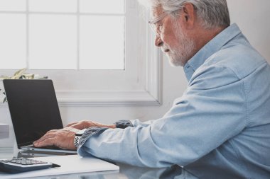 İnternette çalışırken gülümseyen Kafkasyalı mutlu iş adamı laptopta webinar podcast izliyor ve eğitim konferansını öğreniyor notlar alıyor çalışma masasına oturuyor, e-öğrenim kavramı oluşturuyor.   