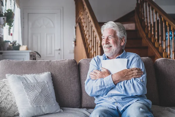 stock image Happy elderly man reading health insurance deal closing looking and reading the medical results. Cheerful mature senior hugging a sheet with the results or outcomes. Checking health tests  