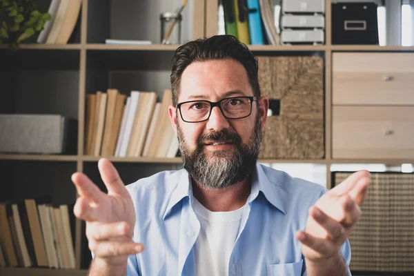 stock image portrait and close up of one old man talking to the camera in video conference or call. Head shot of male person at home in the office working  